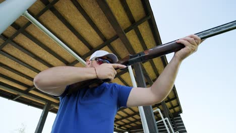 sportsman shoots from a double-barreled shotgun, a sports field for a shooting test is shooting at flying skeet