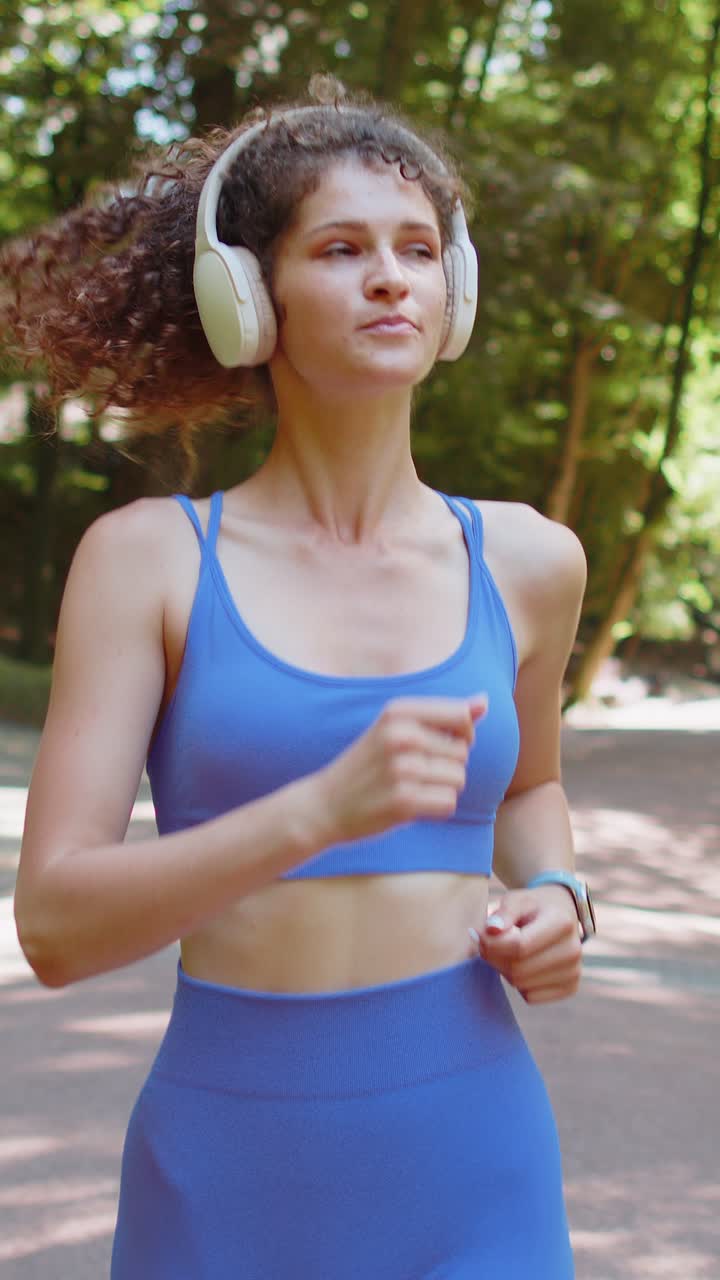 atleta en forma corredor chica corriendo entrenamiento maratón corriendo escuchando música en auriculares inalámbricos en el parque