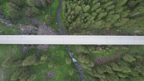 drone looks down from birds eye view towards a bridge