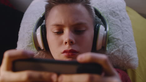 teenage boy playing games on smartphone