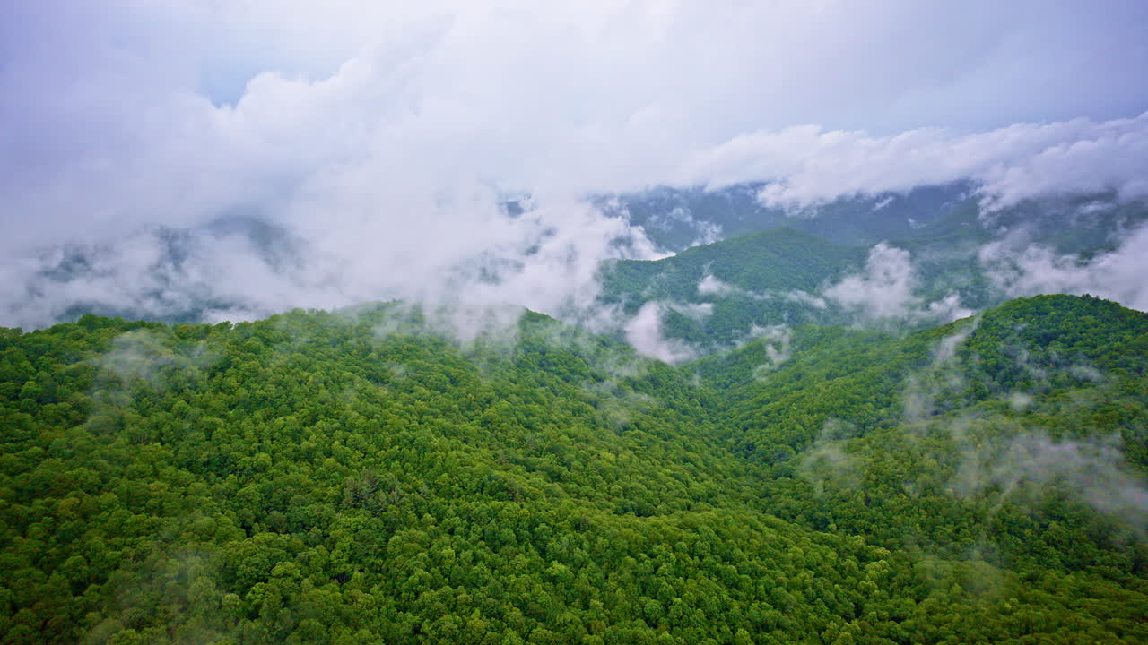 Drone glides through the clouds over the misty Smoky peaks