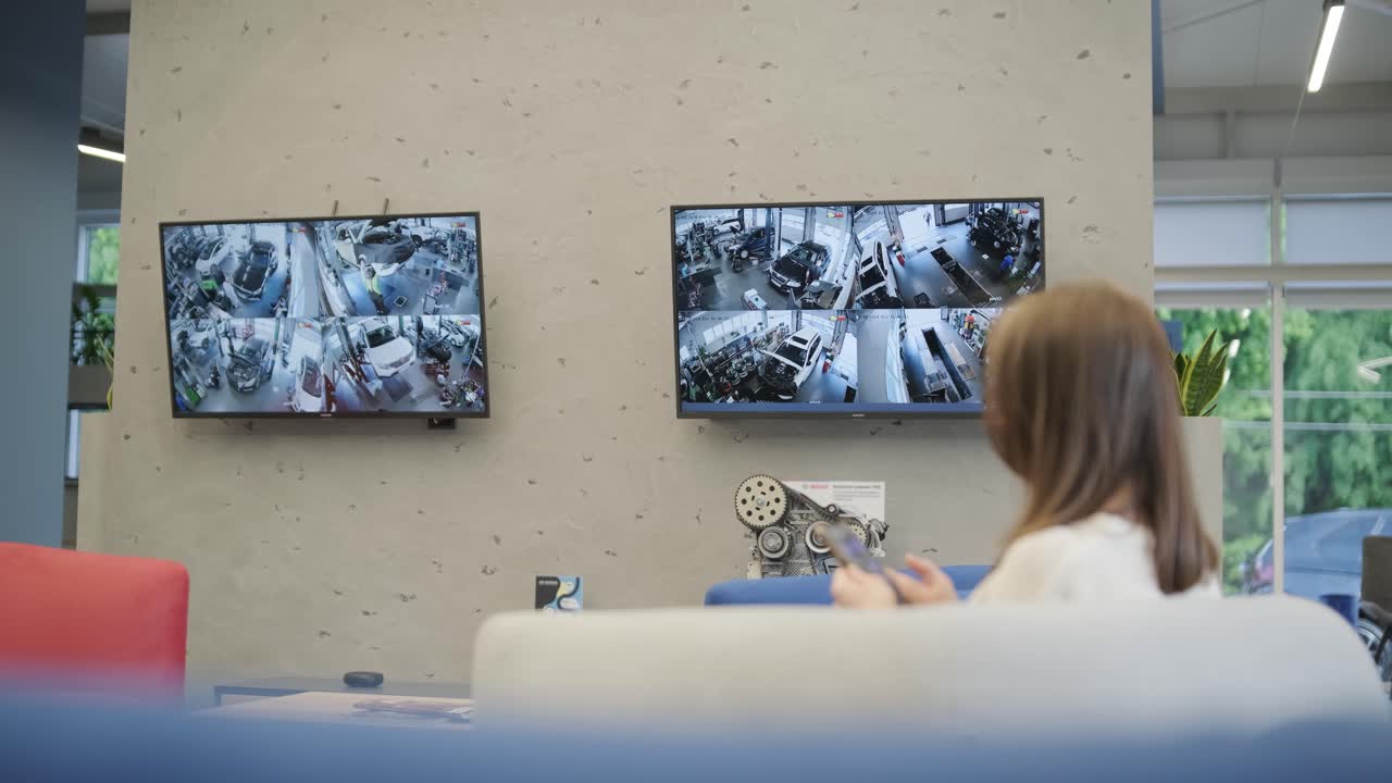 cliente esperando coche en el servicio de coche. cliente viendo el proceso de servicio de coche por transmisión de televisión