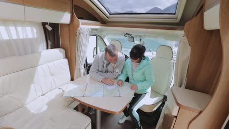 Couples-in-RV-Camper-looking-at-the-local-map-for-the-trip.