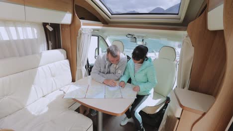 parejas en autocaravanas mirando el mapa local para el viaje.