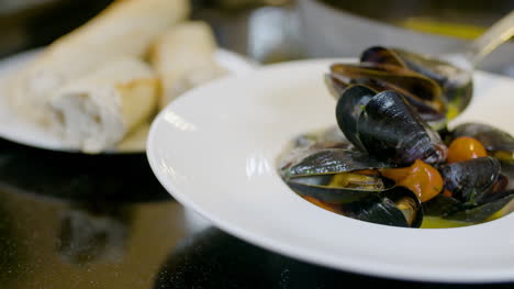 chef is decorating the mussel dish 3