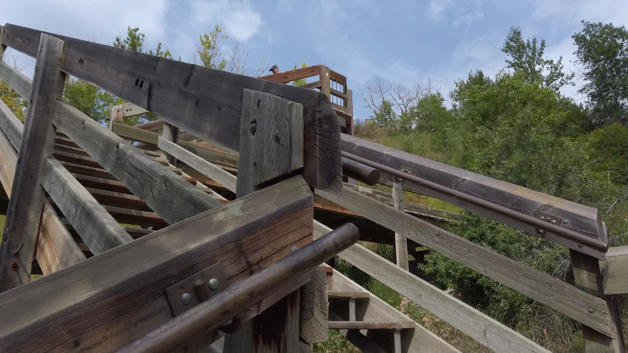 나무로 된 오래된 공원 계단을 내려가는 사람이 캐나다 캘거리 앨버타에 접근했습니다.