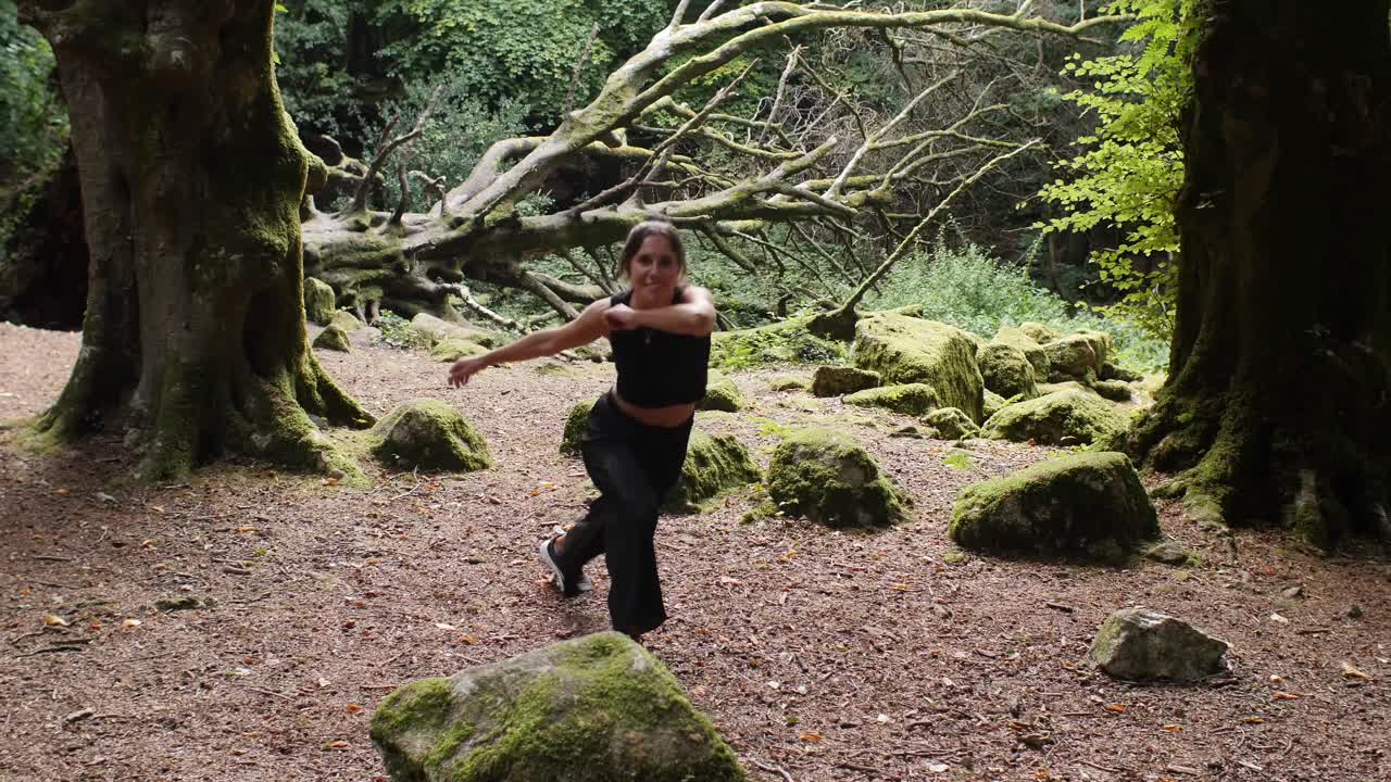 bailarina de capoeira entusiasta haciendo ginga, prado del bosque. slowmo