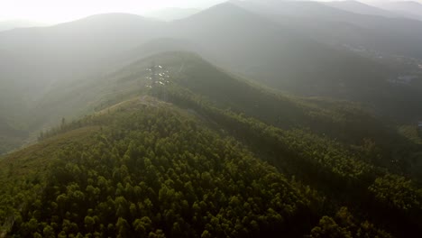 Aerial-view-over-a-mountain-in-a-foggy-scenery,-sunset-in-Portugal