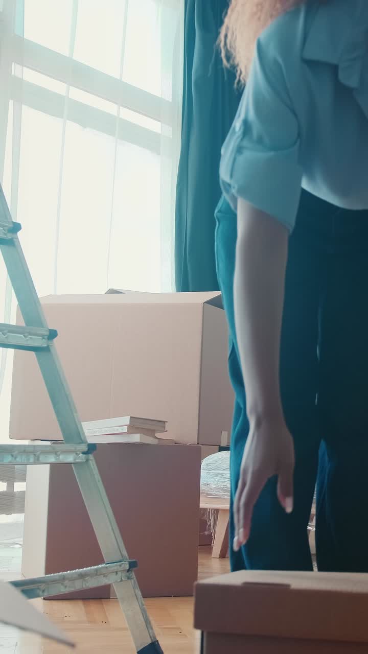 Young strong african american woman is busy moving lifting heavy boxes