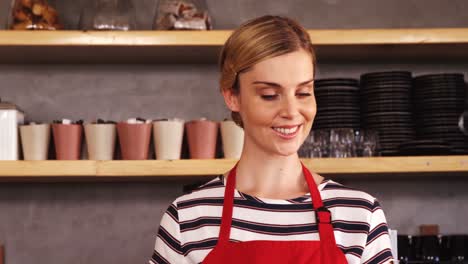 Smiling-waitress-holding-coffee-at-counter