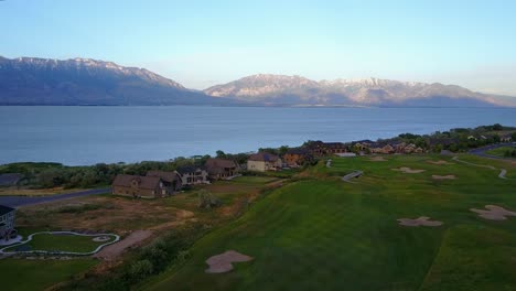 Tiro-De-Dron-Volando-Sobre-Un-Hermoso-Campo-De-Golf-Hacia-El-Lago-Utah