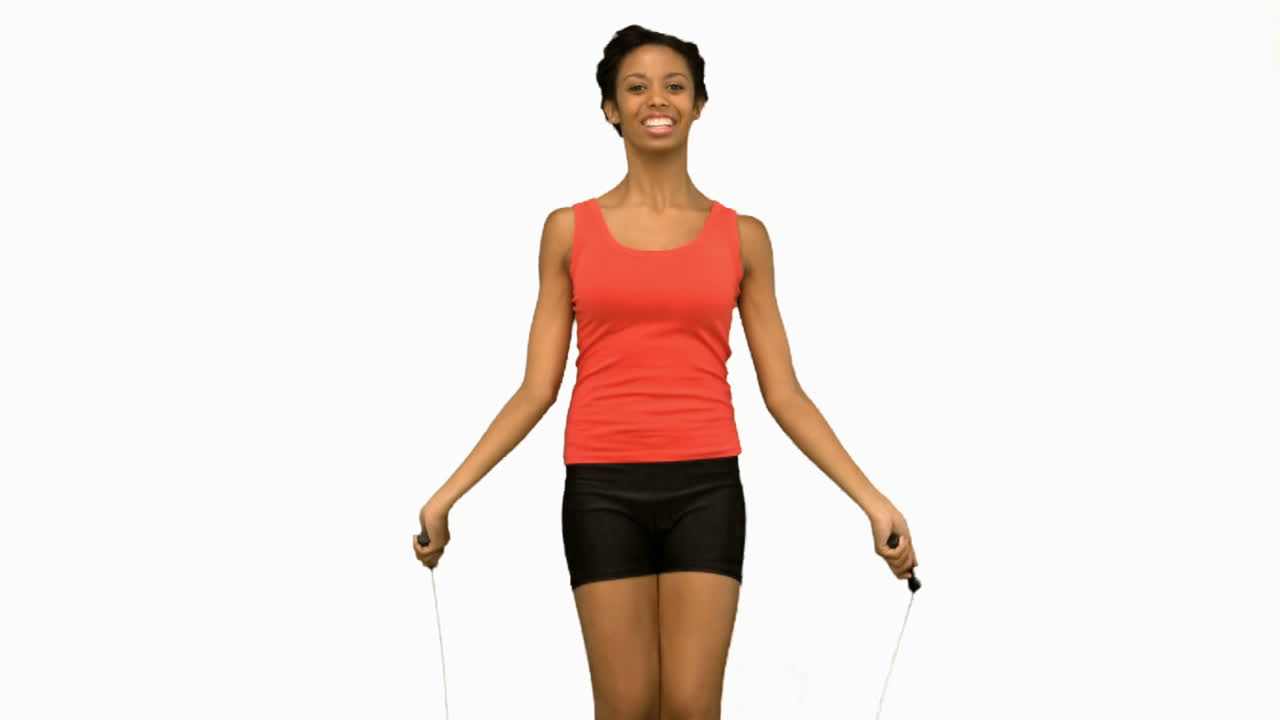 Cheerful woman working out with a rope on white screen