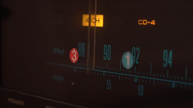 Premendo pulsanti e ruotando manopole su un vecchio amplificatore.