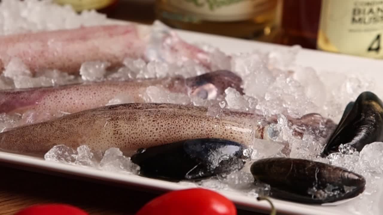 Fresh Raw Squid and Mussels on Ice with Tomatoes