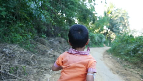 child walking through forest path