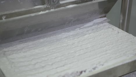 vista de una máquina de fábrica automatizada que corta cuadrados de delicias turcas