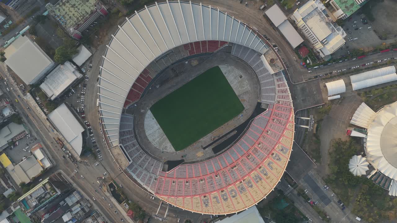 Increíble vista aérea cenital del Estadio Nacional Rajamangala en Bangkok, Tailandia, mostrando el campo de juego, las gradas y la ciudad circundante.