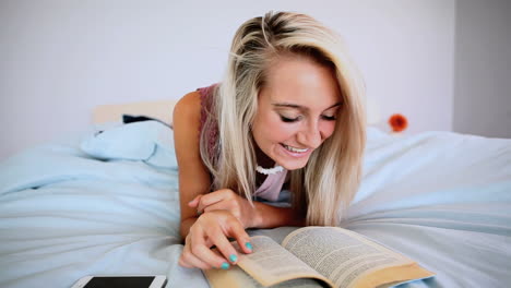 Attraktive-Blondine-Liegt-Auf-Dem-Bett-Und-Liest-Ein-Buch