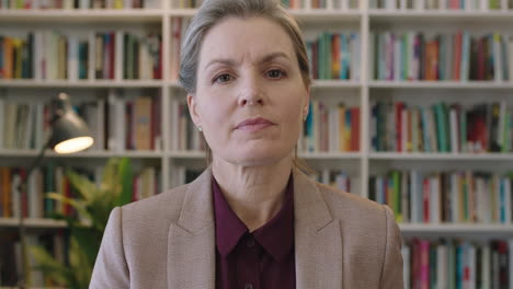 portrait of mature business woman executive looking serious at camera wearing suit in library office background successful career milestone