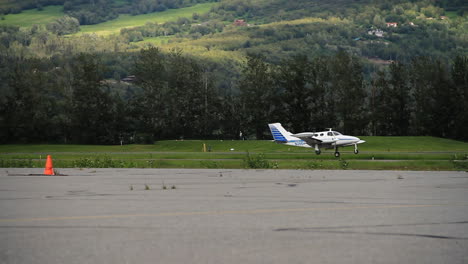 small cessna plane flies by on tarmac