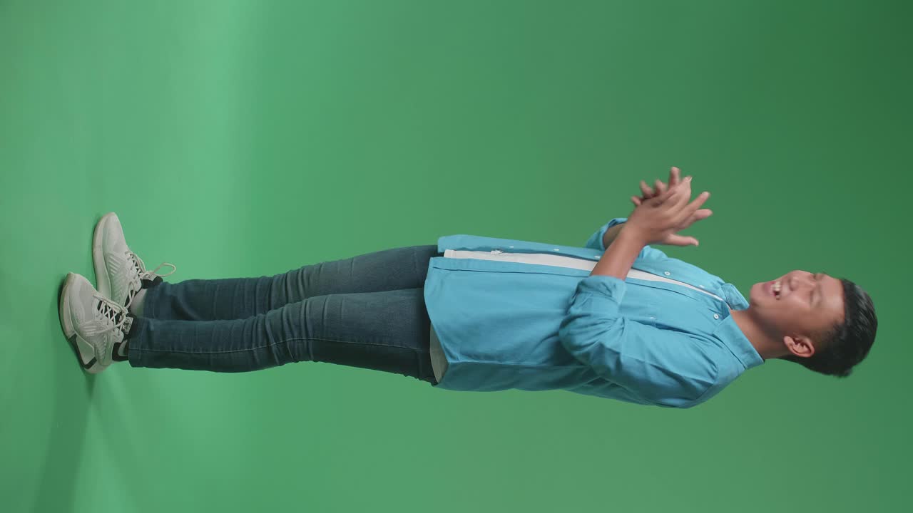 Full Body Of Young Asian Man Clapping Her Hands In The Green Screen Studio. Side View
