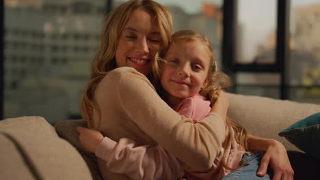 cheerful mother and daughter kissing at home. mom and kid spending time indoors.