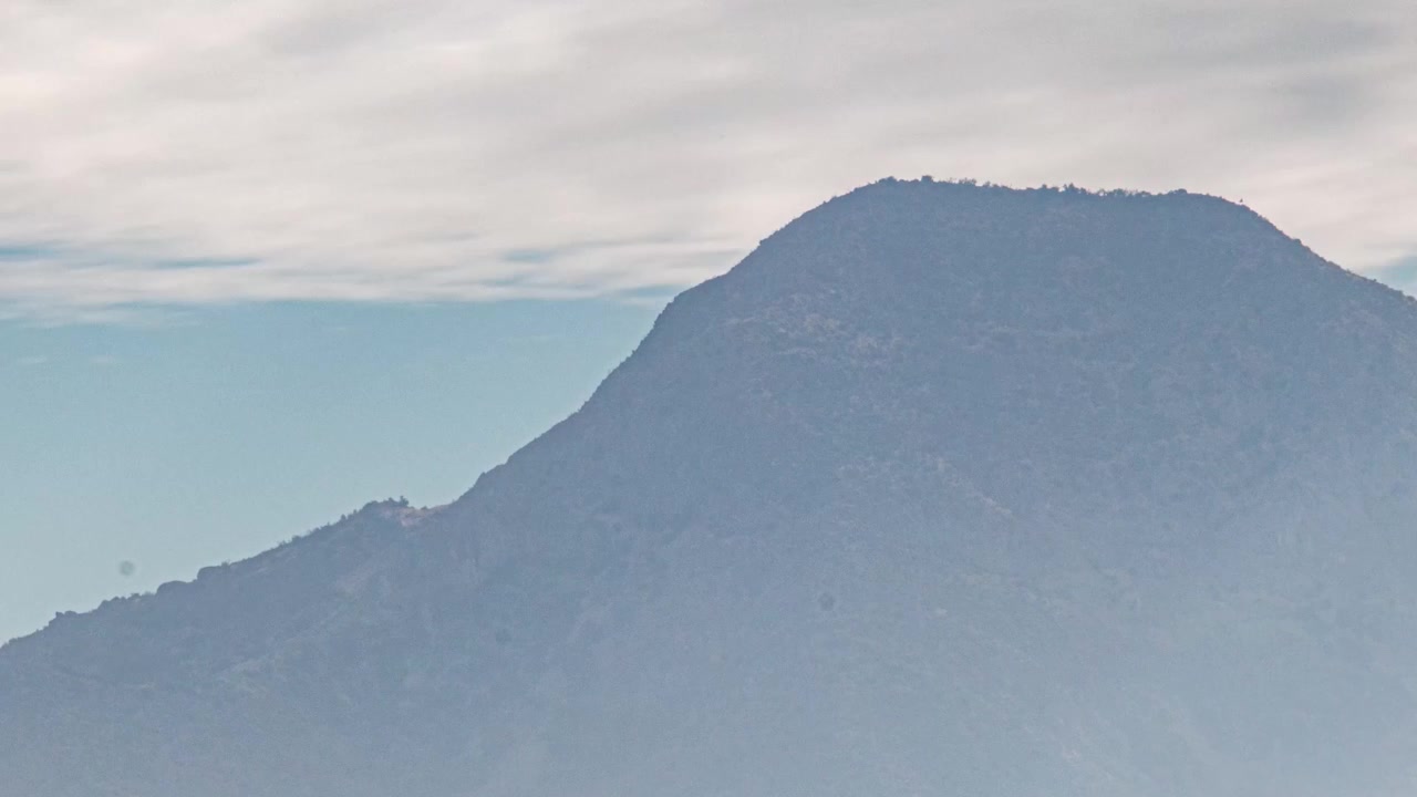 チリのサンティアゴ、セロ・マンケウエの曇りの日の山岳風景。朝の雲のドラマチックなタイムラプス