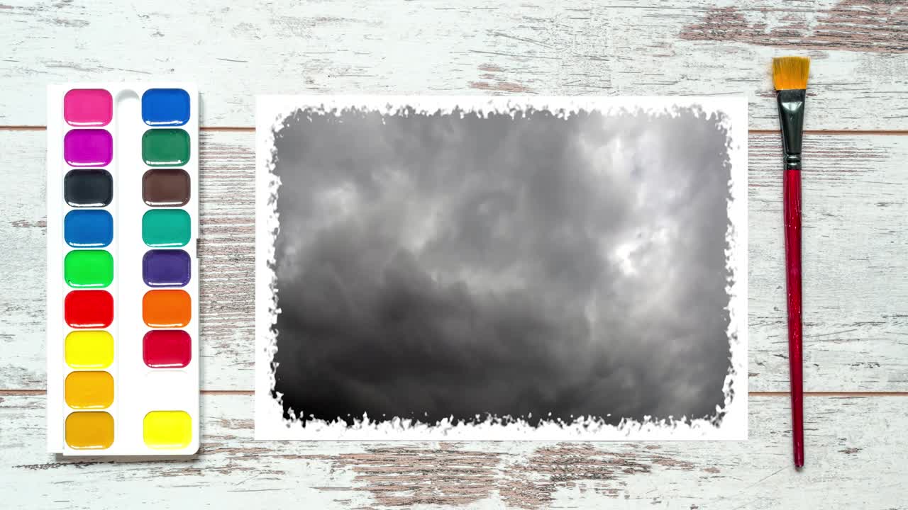 크리에이티브 타임 스 비디오: 브러쉬와 다채로운 페인트 세트, 하늘에서 빠르게 움직이는 구름과 함께 종이 한 장을 가진 빈티지 목조 테이블의 4k.