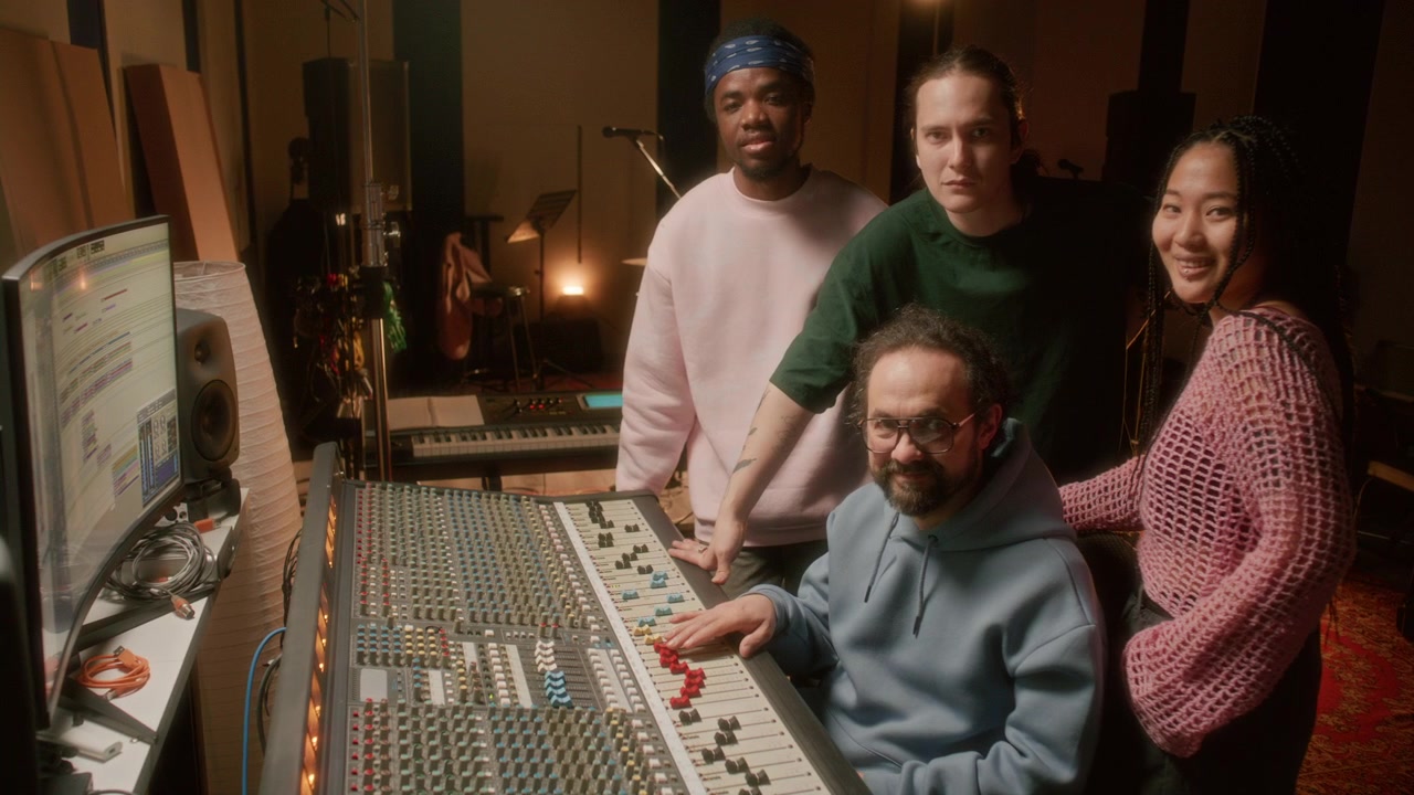 Group Portrait of Cheerful Music Producer and Band in Recording Studio