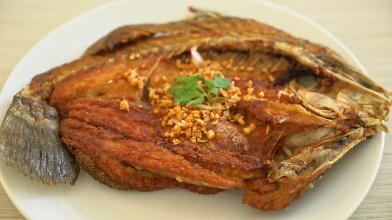 lubina frita con ajo en el plato