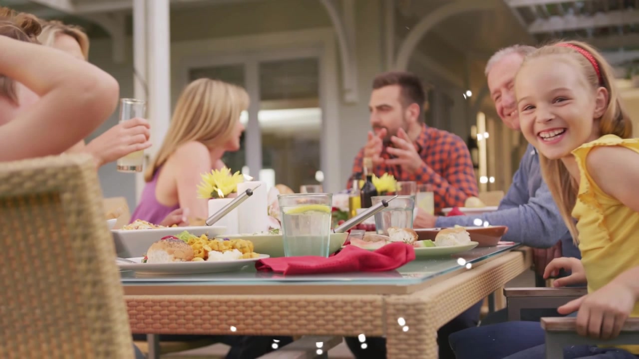 Girl leaning and pressing head to boy pecking sparking family smiles dotted light over faces