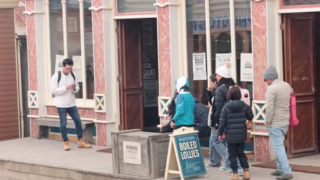 people gather outside a candy shop entrance