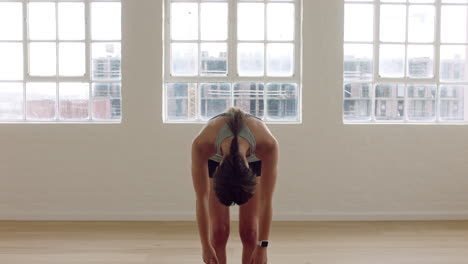 mujer de yoga saludable estirando el cuerpo flexible disfrutando del estilo de vida fitness practicando posturas en el estudio de entrenamiento en la colchoneta de ejercicios al amanecer.