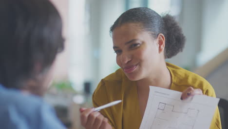 Close-Up-Of-Businessman-And-Businesswoman-Having-Meeting-Sitting-Around-Table-In-Modern-Office