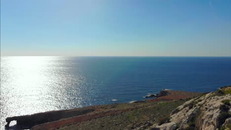 Drone-Disparó-Sobre-Rocas-En-La-Naturaleza-Y-Hacia-Una-Ventana-De-Piedra-Y-Una-Filfla---Una-Pequeña-Isla-En-El-Mar-Mediterráneo-De-Malta