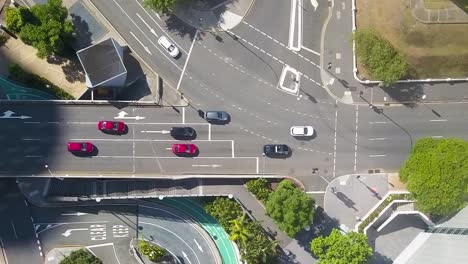 drone top down left to right pan across cars driving along street in multi level roadway