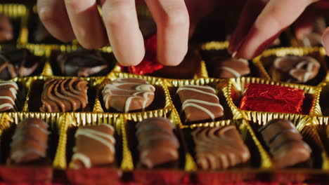 children's and adult hands take one candy from a box