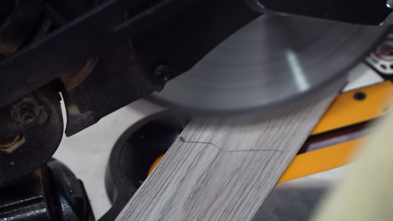 человек, разрезающий ламинатный пол с помощью электрической круговой пилы