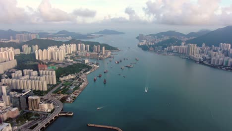 hong kong marina with anchored boats and kwun tong area buildings, aerial view