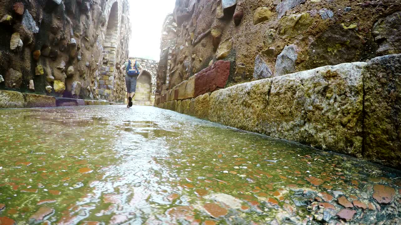 imágenes de acción de 4k de un viajero con mochila caminando alrededor de la mezquita qutb minar en delhi