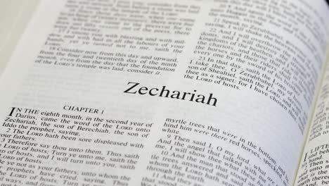 close up shot of bible page turning to the book of zechariah