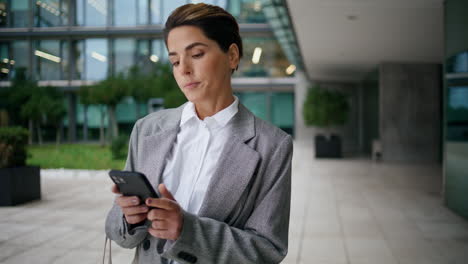 Worried-woman-text-mobile-phone-in-downtown.-Nervous-businesswoman-using-cell