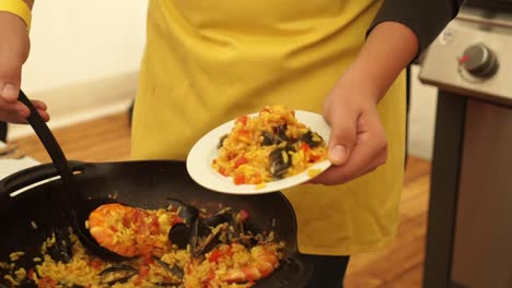 chef preparando paella - gambas, gambas, mejillones, arroz y tomates plato tradicional asiático