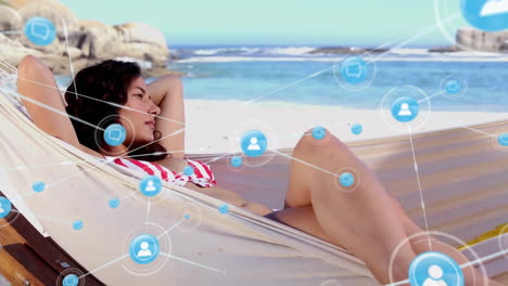 animation of network of connections with icons over biracial woman lying in hammock on beach