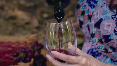 una chica vierte vino en un vaso en cámara lenta.