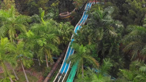 big water slides in middle of green vegetation at waterpark hue vietnam, aerial