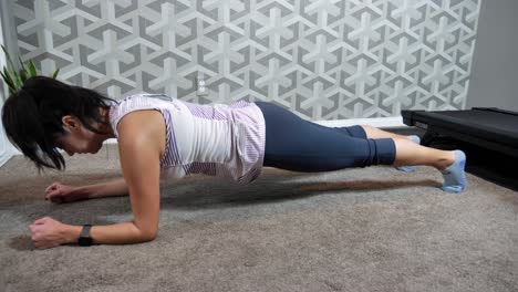 Mujer-Hispana-Sosteniendo-Una-Posición-De-Tablón-En-El-Gimnasio-En-Casa,-Haciendo-Ejercicio