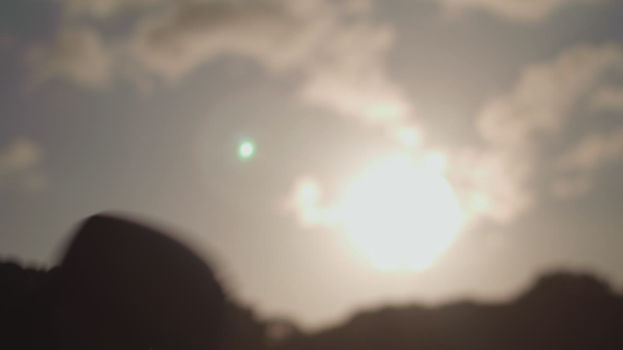 hombre boxeando en el parque, guantes silueteados contra el sol vespertino en cámara lenta