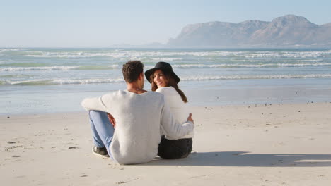 rear view of romantic couple on winter beach vacation