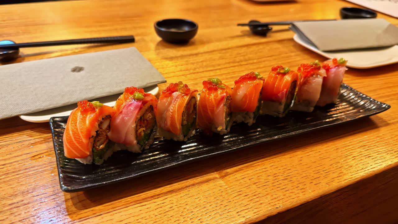 クラクフのレストランで、木製のテーブルに置かれた寿司ロールが食欲をそそります。